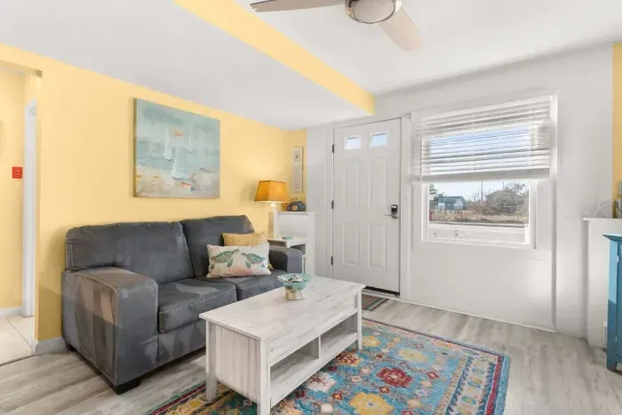 Newly renovated, open kitchen & living room with all new appliances, breakfast bar, 4-seat dining table, couch, accent chair and flat screen smart Roku TV.