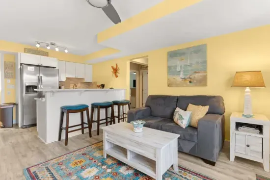 Newly renovated, open kitchen & living room with all new appliances, breakfast bar, 4-seat dining table, couch, accent chair and flat screen smart Roku TV.