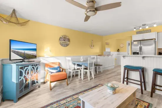 Newly renovated, open kitchen & living room with all new appliances, breakfast bar, 4-seat dining table, couch, accent chair and flat screen smart Roku TV.