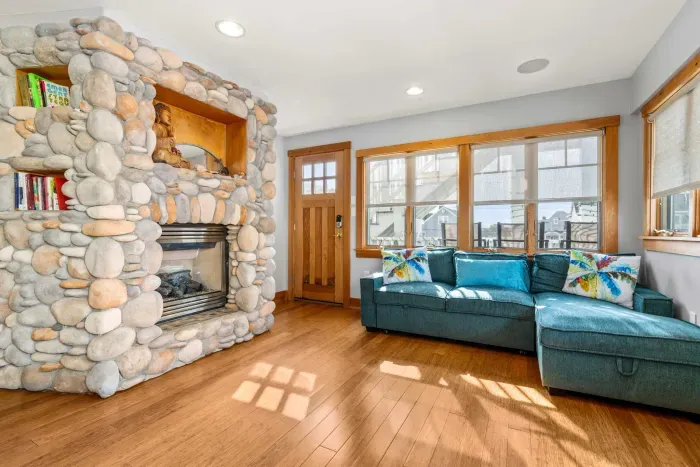 Yoga unit living room with access to the rear of the property via 1 flight of stairs. The couch is a pull out couch suitable for 1 person and a gas fireplace! Small kitchenette with a mini fridge and small sink.