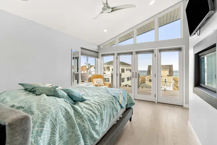 Primary Queen bedroom in the penthouse, with clean linens, gas fireplace smart TV, and incredible ocean views. 