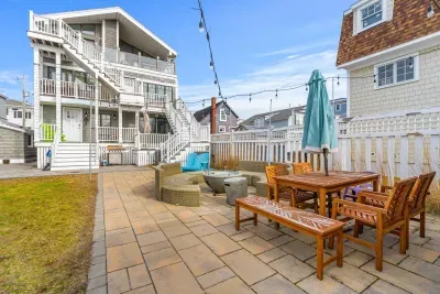 String lights make this backyard space magical at night! There is plenty of outdoor seating, a fun nest house for lounging, a gas fireplace, and 2 gas grills.