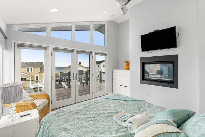 Primary Queen bedroom in the penthouse, with clean linens, gas fireplace smart TV, and incredible ocean views. 