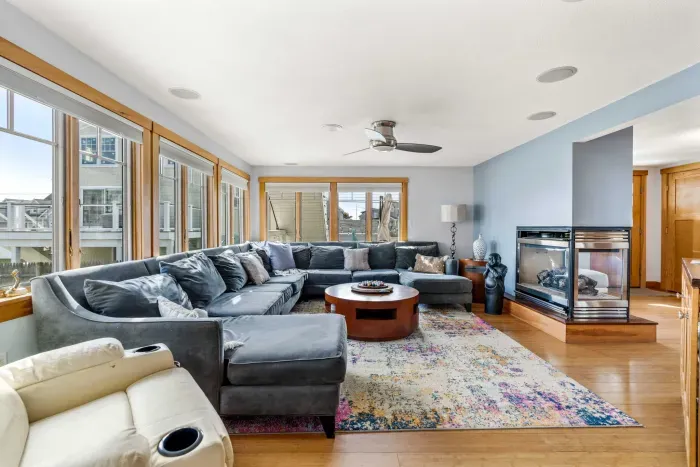🛋️ Namaste Unit Living Room – Bright and spacious with hardwood floors, cozy seating, smart TV, and a modern double-sided fireplace. The spiral staircase heads up to the yoga unit!