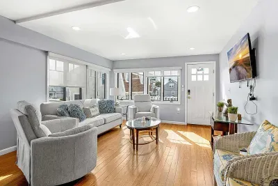 The Nautical unit living room with a smart TV, pull out couch, and secondary access to the rear of the property with backyard and parking access.