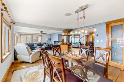Dining area in the Namaste unit with seating for 6. Wet bar is located behind it with a sink and 2 drink fridges. There is extra drink wear in the glass door cabinet.