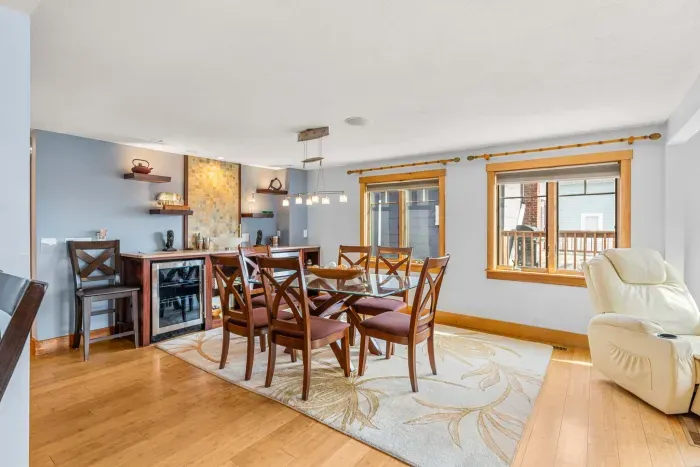 Dining area in the Namaste unit with seating for 6. Wet bar is located behind it with a sink and 2 drink fridges. There is extra drink wear in the glass door cabinet.
