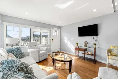 The Nautical unit living room with a smart TV, pull out couch, and secondary access to the rear of the property with backyard and parking access.