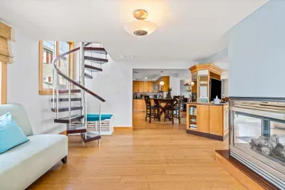 🛋️ Namaste Unit Living Room – Bright and spacious with hardwood floors, cozy seating, smart TV, and a modern double-sided fireplace. The spiral staircase adds a unique touch, making it the perfect spot to relax or gather with family and friends.