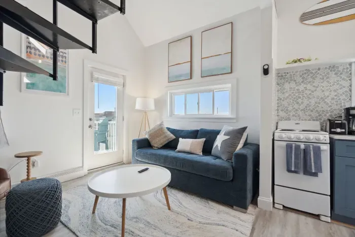 Living room with comfy couch, smart TV, and access to the private balcony