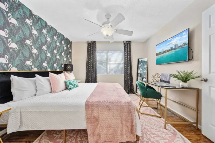 Primary bedroom with king bed, work-from-home desk, smart Roku TV, walk in closet and ensuite bathroom with shower tub.