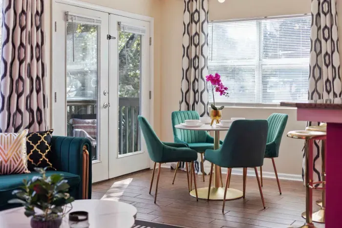 Open kitchen, living room and dining area with smart TV and doors leading to private patio