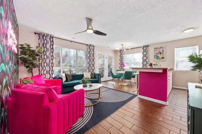 Open kitchen, living room and dining area with smart TV and doors leading to private patio