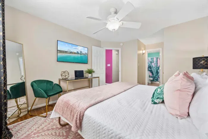 Primary bedroom with king bed, work-from-home desk, smart Roku TV, walk in closet and ensuite bathroom with shower tub.