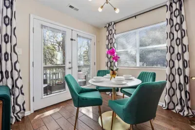 Open kitchen, living room and dining area with smart TV and doors leading to private patio