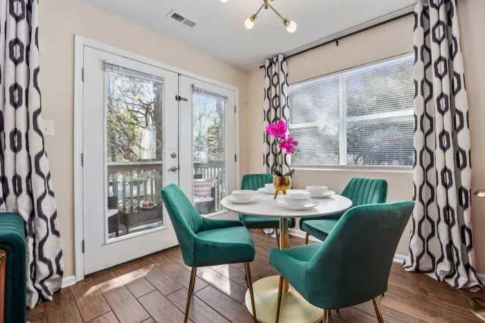 Open kitchen, living room and dining area with smart TV and doors leading to private patio