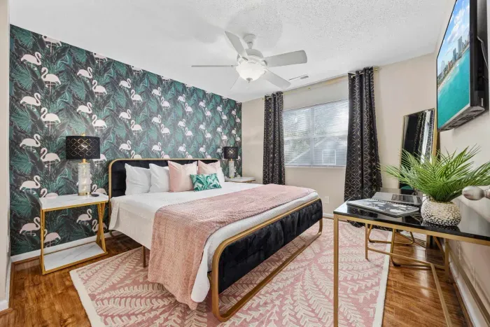 Primary bedroom with king bed, work-from-home desk, smart Roku TV, walk in closet and ensuite bathroom with shower tub.