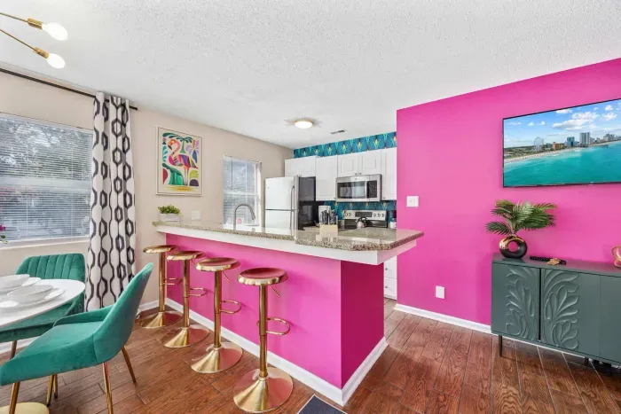 Open kitchen, living room and dining area with smart TV and doors leading to private patio