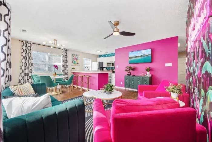 Open kitchen, living room and dining area with smart TV and doors leading to private patio