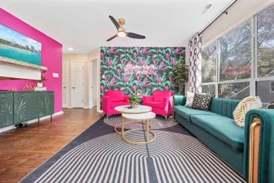 Open kitchen, living room and dining area with smart TV and doors leading to private patio