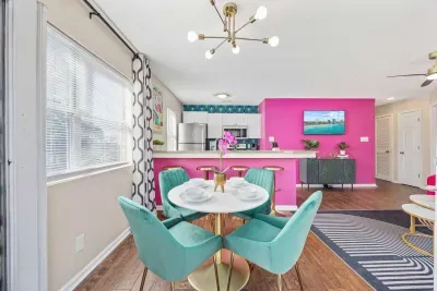 Open kitchen, living room and dining area with smart TV and doors leading to private patio