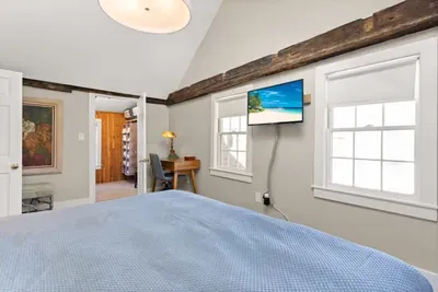 Main bedroom with king bed, vaulted ceilings, flatscreen smart Roku TV, walk in closet and work-from-home desk.