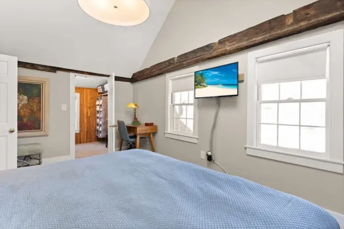 Main bedroom with king bed, vaulted ceilings, flatscreen smart Roku TV, walk in closet and work-from-home desk.