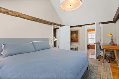 Main bedroom with king bed, vaulted ceilings, flatscreen smart Roku TV, walk in closet and work-from-home desk.