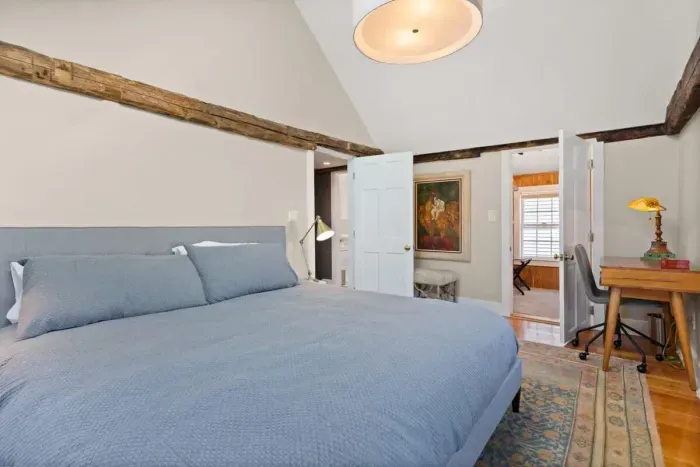 Main bedroom with king bed, vaulted ceilings, flatscreen smart Roku TV, walk in closet and work-from-home desk.