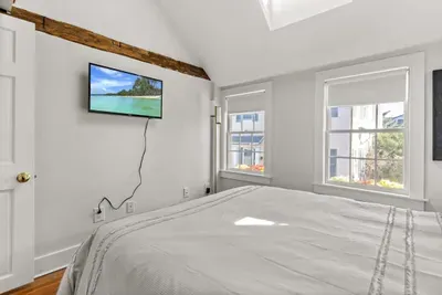 Bedroom #2 with queen bed, vaulted ceilings, flatscreen smart Roku TV, and closet.