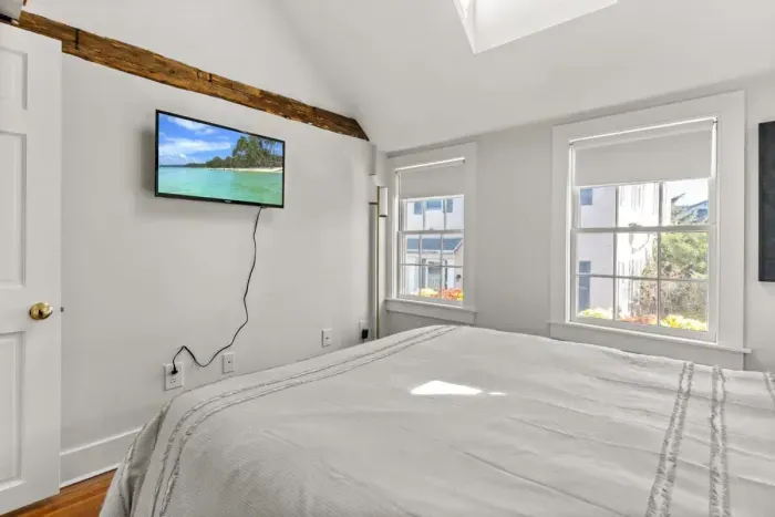 Bedroom #2 with queen bed, vaulted ceilings, flatscreen smart Roku TV, and closet.