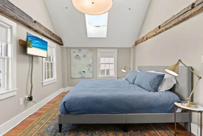 Main bedroom with king bed, vaulted ceilings, flatscreen smart Roku TV, walk in closet and work-from-home desk.