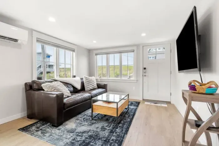 Fully equipped open kitchen and living room with large island, high-end appliances, kitchen table, washer/dryer, smart tv