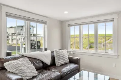 Fully equipped open kitchen and living room with large island, high-end appliances, kitchen table, washer/dryer, smart tv