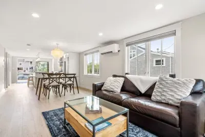 Fully equipped open kitchen and living room with large island, high-end appliances, kitchen table, washer/dryer, smart tv