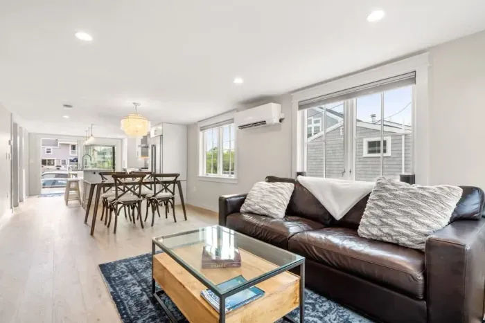 Fully equipped open kitchen and living room with large island, high-end appliances, kitchen table, washer/dryer, smart tv