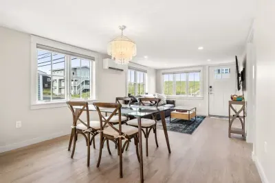 Fully equipped open kitchen and living room with large island, high-end appliances, kitchen table, washer/dryer, smart tv