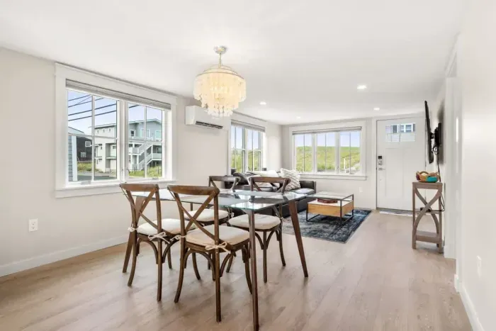 Fully equipped open kitchen and living room with large island, high-end appliances, kitchen table, washer/dryer, smart tv