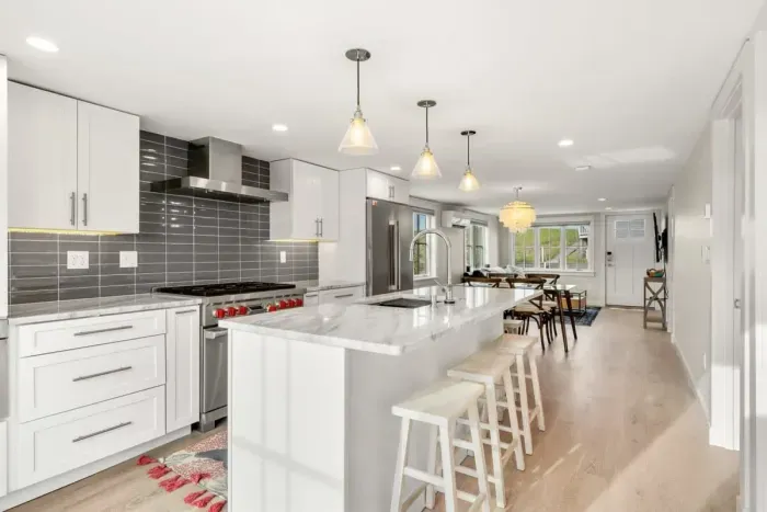 Fully equipped open kitchen and living room with large island, high-end appliances, kitchen table, washer/dryer, smart tv