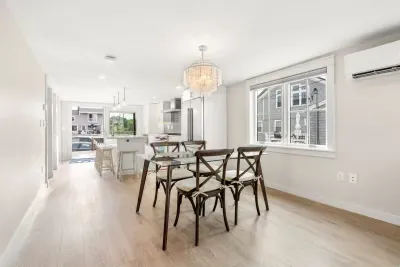 Fully equipped open kitchen and living room with large island, high-end appliances, kitchen table, washer/dryer, smart tv