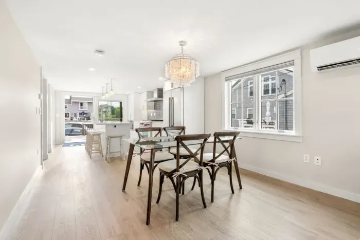 Fully equipped open kitchen and living room with large island, high-end appliances, kitchen table, washer/dryer, smart tv