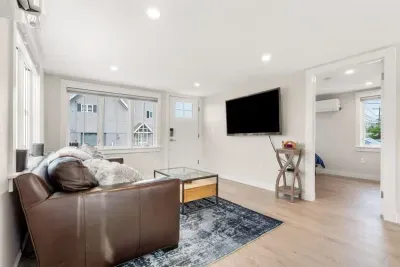 Fully equipped open kitchen and living room with large island, high-end appliances, kitchen table, washer/dryer, smart tv