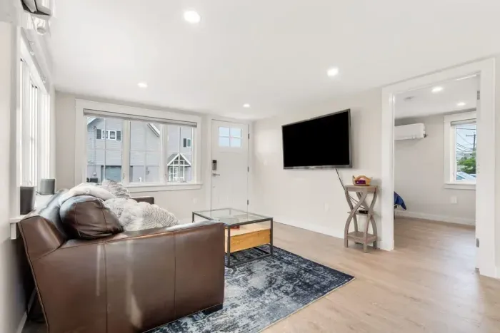 Fully equipped open kitchen and living room with large island, high-end appliances, kitchen table, washer/dryer, smart tv