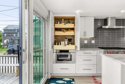 Fully equipped open kitchen and living room with large island, high-end appliances, kitchen table, washer/dryer, smart tv