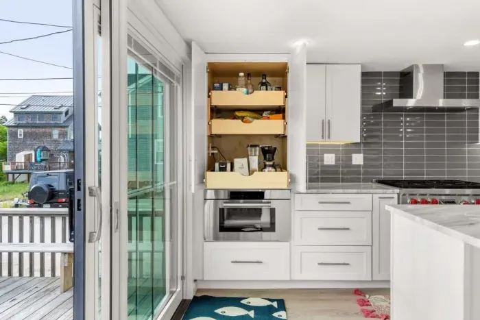 Fully equipped open kitchen and living room with large island, high-end appliances, kitchen table, washer/dryer, smart tv