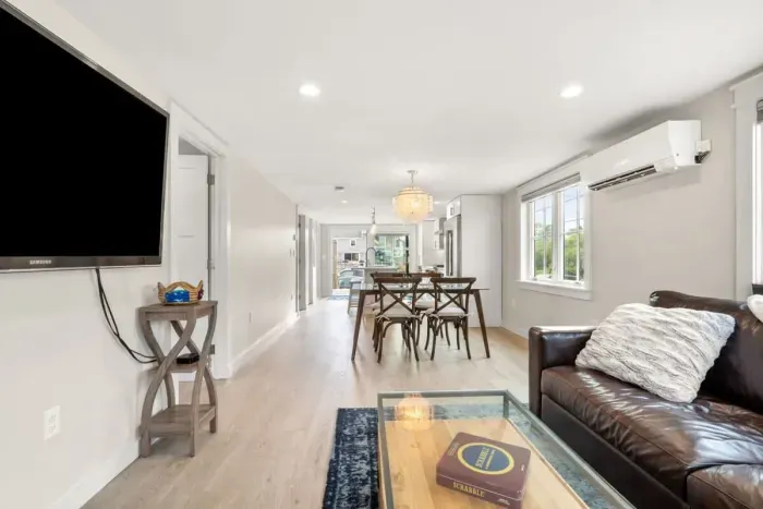 Fully equipped open kitchen and living room with large island, high-end appliances, kitchen table, washer/dryer, smart tv