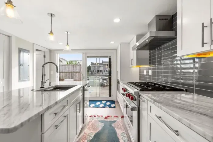 Fully equipped open kitchen and living room with large island, high-end appliances, kitchen table, washer/dryer, smart tv