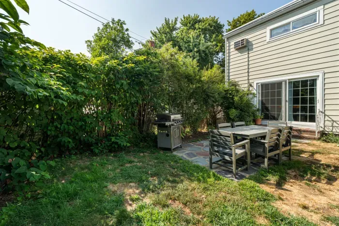 Backyard with new outdoor furniture, seating for 6, and a gas grill.