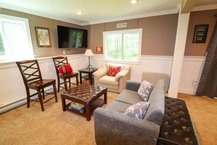 The game room! Featuring a sleeper sofa, 4 person table, and direct access to the back deck and patio.