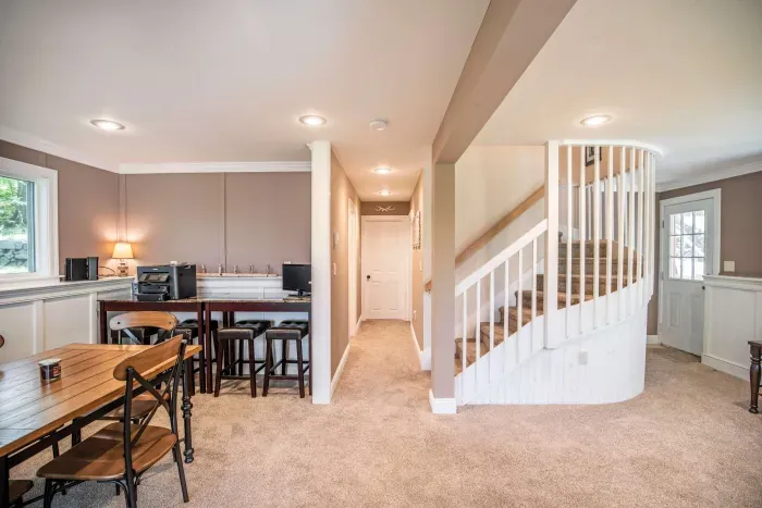 The game room! Featuring a sleeper sofa, 4 person table, and direct access to the back deck and patio.